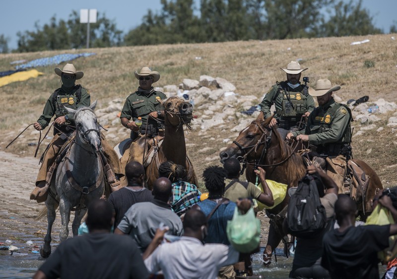 Patroli Perbatasan Amerika Serikat (AS) menggunakan kuda dalam operasi imigran ilegal Haiti U.S. Customs and Border Protection mounted officers attempt to contain migrants as they cross the Rio Grande from Ciudad Acuna, Mexico, into Del Rio, Texas, Sunday, Sept. 19, 2021. Criticism has been fueled by the images that went viral this week of Border Patrol agents on horseback using aggressive tactics against the migrants. (AP Photo/Felix Marquez)