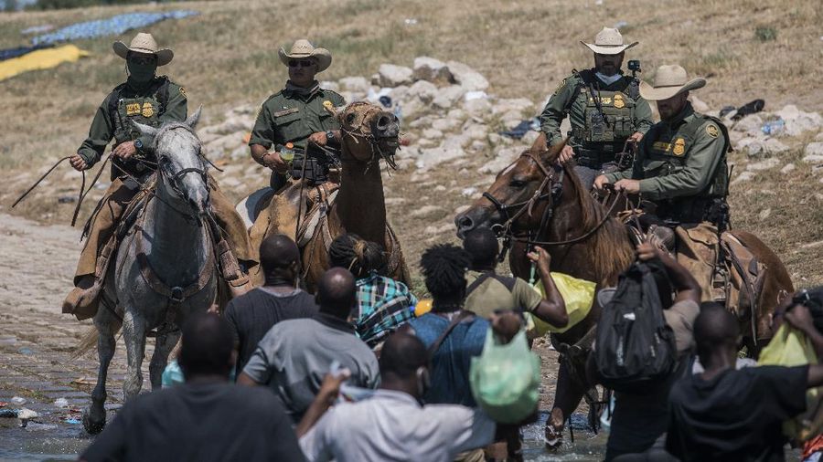 U.S. Customs and Border Protection mounted officers attempt to contain migrants as they cross the Rio Grande from Ciudad Acuna, Mexico, into Del Rio, Texas, Sunday, Sept. 19, 2021. Criticism has been fueled by the images that went viral this week of Border Patrol agents on horseback using aggressive tactics against the migrants. (AP Photo/Felix Marquez)