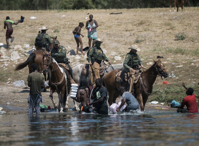 Patroli Perbatasan Amerika Serikat (AS) menggunakan kuda dalam operasi imigran ilegal Haiti U.S. Customs and Border Protection mounted officers attempt to contain migrants as they cross the Rio Grande from Ciudad Acuna, Mexico, into Del Rio, Texas, Sunday, Sept. 19, 2021. Criticism has been fueled by the images that went viral this week of Border Patrol agents on horseback using aggressive tactics against the migrants. (AP Photo/Felix Marquez)