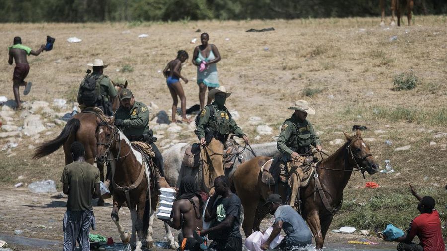 U.S. Customs and Border Protection mounted officers attempt to contain migrants as they cross the Rio Grande from Ciudad Acuna, Mexico, into Del Rio, Texas, Sunday, Sept. 19, 2021. Criticism has been fueled by the images that went viral this week of Border Patrol agents on horseback using aggressive tactics against the migrants. (AP Photo/Felix Marquez)