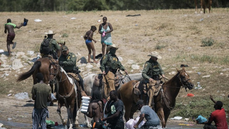 U.S. Customs and Border Protection mounted officers attempt to contain migrants as they cross the Rio Grande from Ciudad Acuna, Mexico, into Del Rio, Texas, Sunday, Sept. 19, 2021. Criticism has been fueled by the images that went viral this week of Border Patrol agents on horseback using aggressive tactics against the migrants. (AP Photo/Felix Marquez)