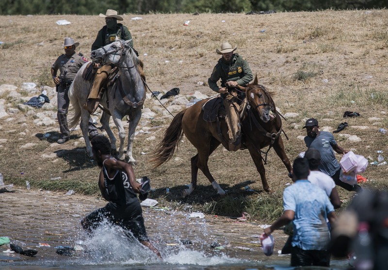 Patroli Perbatasan Amerika Serikat (AS) menggunakan kuda dalam operasi imigran ilegal Haiti U.S. Customs and Border Protection mounted officers attempt to contain migrants as they cross the Rio Grande from Ciudad Acuna, Mexico, into Del Rio, Texas, Sunday, Sept. 19, 2021. Criticism has been fueled by the images that went viral this week of Border Patrol agents on horseback using aggressive tactics against the migrants. (AP Photo/Felix Marquez)