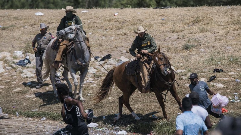 U.S. Customs and Border Protection mounted officers attempt to contain migrants as they cross the Rio Grande from Ciudad Acuna, Mexico, into Del Rio, Texas, Sunday, Sept. 19, 2021. Criticism has been fueled by the images that went viral this week of Border Patrol agents on horseback using aggressive tactics against the migrants. (AP Photo/Felix Marquez)
