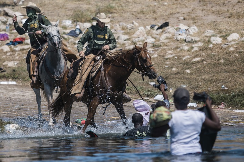 U.S. Customs and Border Protection mounted officers attempt to contain migrants as they cross the Rio Grande from Ciudad Acuna, Mexico, into Del Rio, Texas, Sunday, Sept. 19, 2021. Criticism has been fueled by the images that went viral this week of Border Patrol agents on horseback using aggressive tactics against the migrants. (AP Photo/Felix Marquez)
