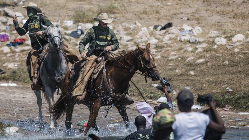 U.S. Customs and Border Protection mounted officers attempt to contain migrants as they cross the Rio Grande from Ciudad Acuna, Mexico, into Del Rio, Texas, Sunday, Sept. 19, 2021. Criticism has been fueled by the images that went viral this week of Border Patrol agents on horseback using aggressive tactics against the migrants. (AP Photo/Felix Marquez)
