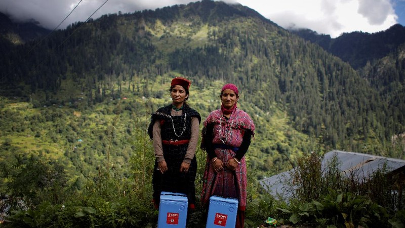 Health workers carry medical kits and a box containing COVISHIELD vaccines, before starting their trek through the mountains to vaccinate people in remote villages, as a part of a vaccination drive, during the coronavirus disease (COVID-19) outbreak, near Malana village in Kullu district in the Himalayan state of Himachal Pradesh, India, September 14, 2021. Despite the hostile terrain, the northern state of Himachal Pradesh became the first in India to administer at least one COVID-19 vaccine dose in all its adults. The steep topography was a challenge overcome by health workers walking for hours or days to reach remote villages.  REUTERS/Adnan Abidi      SEARCH 