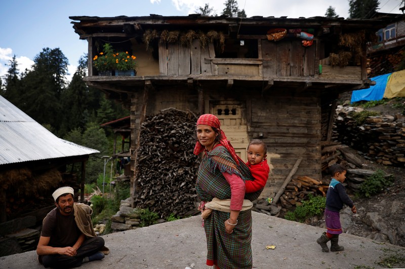 Health workers carry medical kits and a box containing COVISHIELD vaccines, before starting their trek through the mountains to vaccinate people in remote villages, as a part of a vaccination drive, during the coronavirus disease (COVID-19) outbreak, near Malana village in Kullu district in the Himalayan state of Himachal Pradesh, India, September 14, 2021. Despite the hostile terrain, the northern state of Himachal Pradesh became the first in India to administer at least one COVID-19 vaccine dose in all its adults. The steep topography was a challenge overcome by health workers walking for hours or days to reach remote villages.  REUTERS/Adnan Abidi      SEARCH 