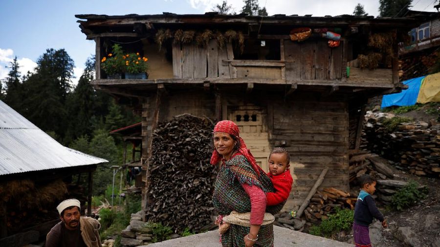 Health workers carry medical kits and a box containing COVISHIELD vaccines, before starting their trek through the mountains to vaccinate people in remote villages, as a part of a vaccination drive, during the coronavirus disease (COVID-19) outbreak, near Malana village in Kullu district in the Himalayan state of Himachal Pradesh, India, September 14, 2021. Despite the hostile terrain, the northern state of Himachal Pradesh became the first in India to administer at least one COVID-19 vaccine dose in all its adults. The steep topography was a challenge overcome by health workers walking for hours or days to reach remote villages.  REUTERS/Adnan Abidi      SEARCH 