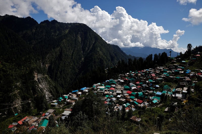 Health workers carry medical kits and a box containing COVISHIELD vaccines, before starting their trek through the mountains to vaccinate people in remote villages, as a part of a vaccination drive, during the coronavirus disease (COVID-19) outbreak, near Malana village in Kullu district in the Himalayan state of Himachal Pradesh, India, September 14, 2021. Despite the hostile terrain, the northern state of Himachal Pradesh became the first in India to administer at least one COVID-19 vaccine dose in all its adults. The steep topography was a challenge overcome by health workers walking for hours or days to reach remote villages.  REUTERS/Adnan Abidi      SEARCH 