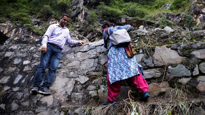 Health workers carry medical kits and a box containing COVISHIELD vaccines, before starting their trek through the mountains to vaccinate people in remote villages, as a part of a vaccination drive, during the coronavirus disease (COVID-19) outbreak, near Malana village in Kullu district in the Himalayan state of Himachal Pradesh, India, September 14, 2021. Despite the hostile terrain, the northern state of Himachal Pradesh became the first in India to administer at least one COVID-19 vaccine dose in all its adults. The steep topography was a challenge overcome by health workers walking for hours or days to reach remote villages.  REUTERS/Adnan Abidi      SEARCH 
