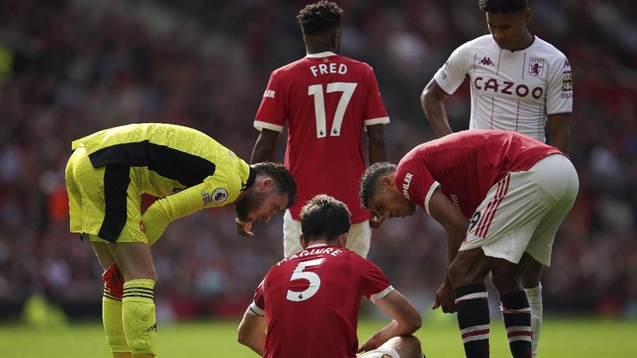 Manchester United's Harry Maguire (5) is injured during the English Premier League soccer match between Manchester United and Aston Villa at the Old Trafford stadium in Manchester, England, Saturday, Sept 25, 2021. (AP Photo/Jon Super)