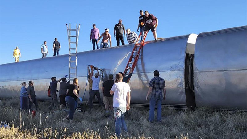 In this photo provided by Kimberly Fossen people work at the scene of an Amtrak train derailment on Saturday, Sept. 25, 2021, in north-central Montana. Multiple people were injured when the train that runs between Seattle and Chicago derailed Saturday, the train agency said. (Kimberly Fossen via AP)