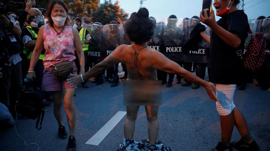 SENSITIVE MATERIAL. THIS IMAGE MAY OFFEND OR DISTURB  A demonstrator reacts in front of police during a protest over the Thai government's handling of the coronavirus disease (COVID-19) pandemic and to demand Prime Minister Prayuth Chan-ocha's resignation, in Bangkok, Thailand, September 28, 2021. REUTERS/Soe Zeya Tun