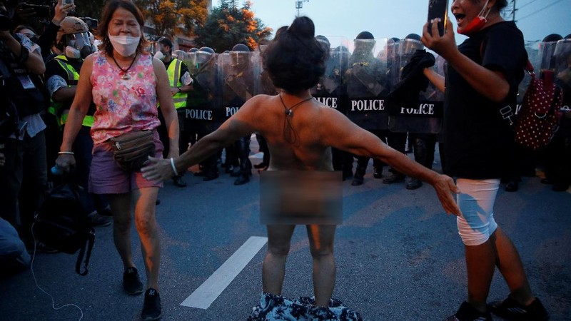 SENSITIVE MATERIAL. THIS IMAGE MAY OFFEND OR DISTURB  A demonstrator reacts in front of police during a protest over the Thai government's handling of the coronavirus disease (COVID-19) pandemic and to demand Prime Minister Prayuth Chan-ocha's resignation, in Bangkok, Thailand, September 28, 2021. REUTERS/Soe Zeya Tun