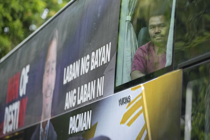 Supporters of retired Filipino boxing star and senator Manny Pacquiao gather near an area where he will file his certificate of candidacy for next year's presidential elections before the Commission on Elections on Friday, Oct. 1, 2021 in Manila, Philippines. Friday marks the start of a weeklong registration period for candidates seeking to lead a Southeast Asian nation that has been hit hard by the pandemic and deep political conflicts.(AP Photo/Aaron Favila)