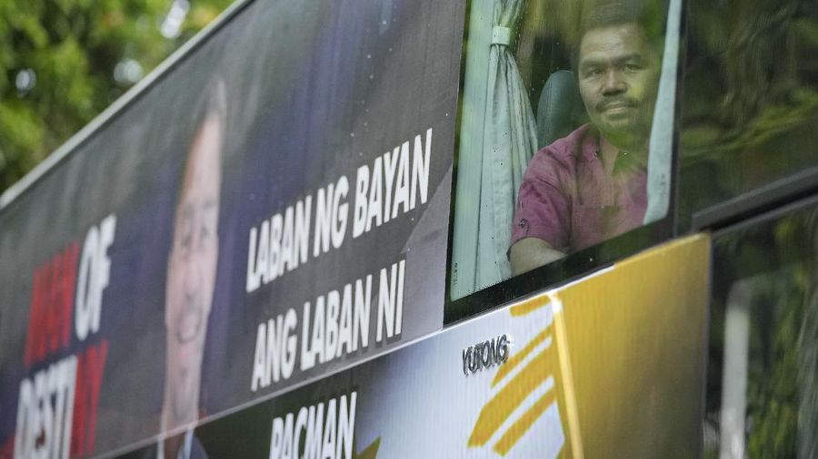 Supporters of retired Filipino boxing star and senator Manny Pacquiao gather near an area where he will file his certificate of candidacy for next year's presidential elections before the Commission on Elections on Friday, Oct. 1, 2021 in Manila, Philippines. Friday marks the start of a weeklong registration period for candidates seeking to lead a Southeast Asian nation that has been hit hard by the pandemic and deep political conflicts.(AP Photo/Aaron Favila)