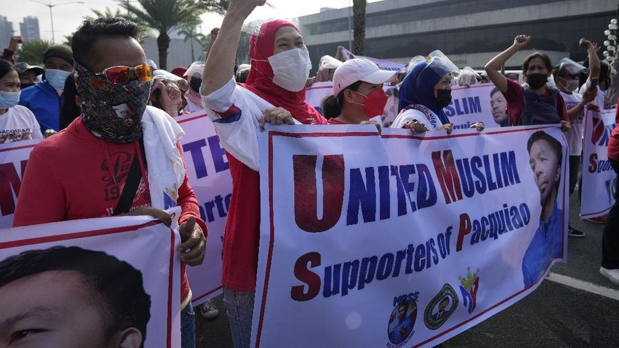 Supporters of retired Filipino boxing star and senator Manny Pacquiao gather near an area where he will file his certificate of candidacy for next year's presidential elections before the Commission on Elections on Friday, Oct. 1, 2021 in Manila, Philippines. Friday marks the start of a weeklong registration period for candidates seeking to lead a Southeast Asian nation that has been hit hard by the pandemic and deep political conflicts.(AP Photo/Aaron Favila)