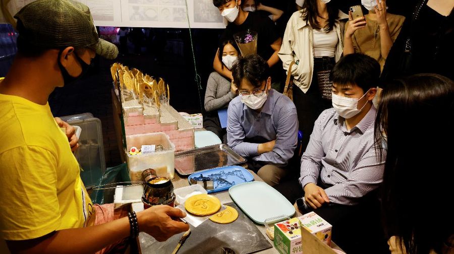 A street vendor sells Dalgona candy from the Korean Netflix series 
