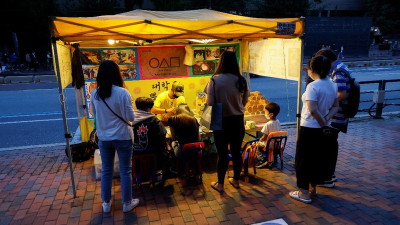 A street vendor sells Dalgona candy from the Korean Netflix series 