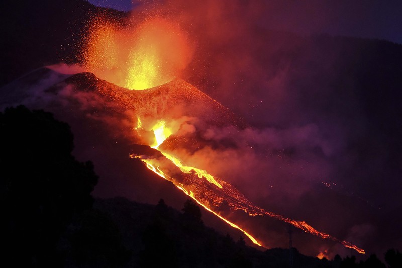 SPAIN-VOLCANO/ A woman climbs a hill with a child to see the Cumbre Vieja volcano as it continues to erupt in Tacande de Arriba on the Canary Island of La Palma, Spain, October 2, 2021. REUTERS/Juan Medina TPX IMAGES OF THE DAY