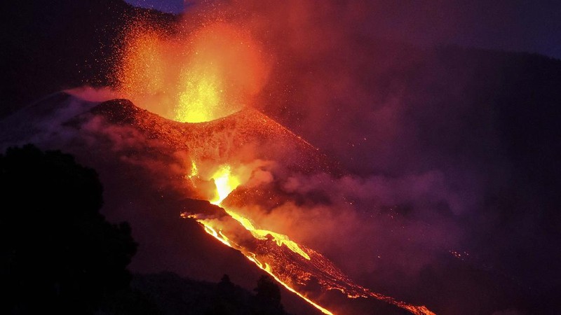 A woman climbs a hill with a child to see the Cumbre Vieja volcano as it continues to erupt in Tacande de Arriba on the Canary Island of La Palma, Spain, October 2, 2021. REUTERS/Juan Medina     TPX IMAGES OF THE DAY