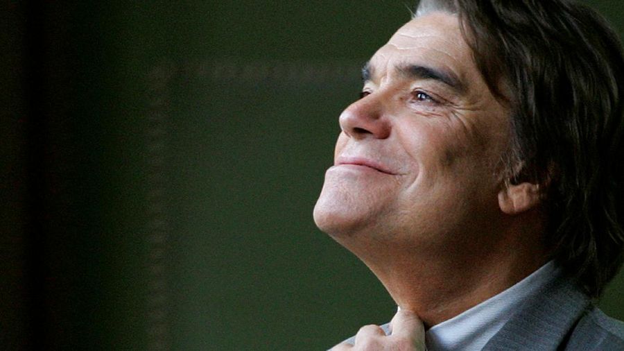 FILE PHOTO: French businessman Bernard Tapie adjusts his tie at the Justice court in Paris in this file photo October 19, 2005. Tapie is being questioned by police in Paris June 24, 2013 in a widening probe into the French government's 2008 decision to award the French businessman a 285 million euro ($374 million) arbitration payment as part of his long-running battle with now-defunct bank Credit Lyonnais over the 1993 sale of his stake in sports clothing firm Adidas. Picture taken October 19, 2005 REUTERS/Charles Platiau/File Photo