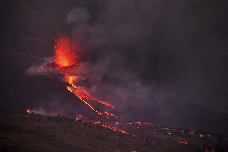 SPAIN-VOLCANO/ A woman climbs a hill with a child to see the Cumbre Vieja volcano as it continues to erupt in Tacande de Arriba on the Canary Island of La Palma, Spain, October 2, 2021. REUTERS/Juan Medina TPX IMAGES OF THE DAY