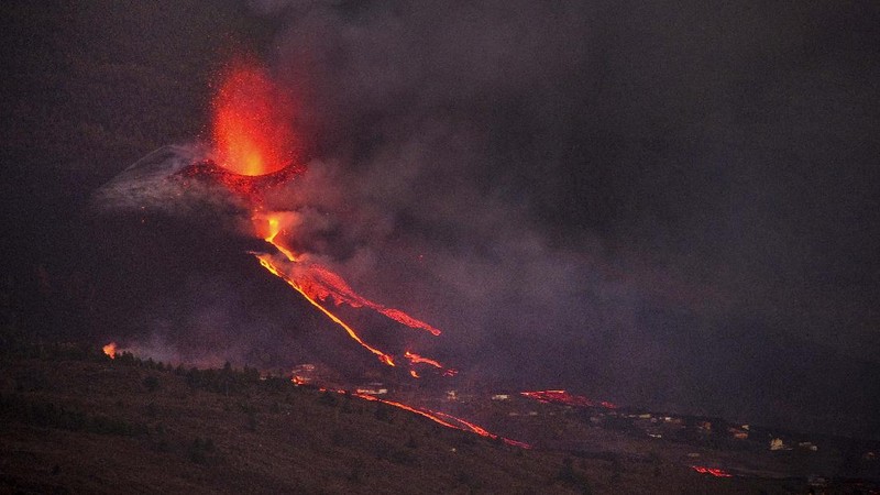 A woman climbs a hill with a child to see the Cumbre Vieja volcano as it continues to erupt in Tacande de Arriba on the Canary Island of La Palma, Spain, October 2, 2021. REUTERS/Juan Medina     TPX IMAGES OF THE DAY