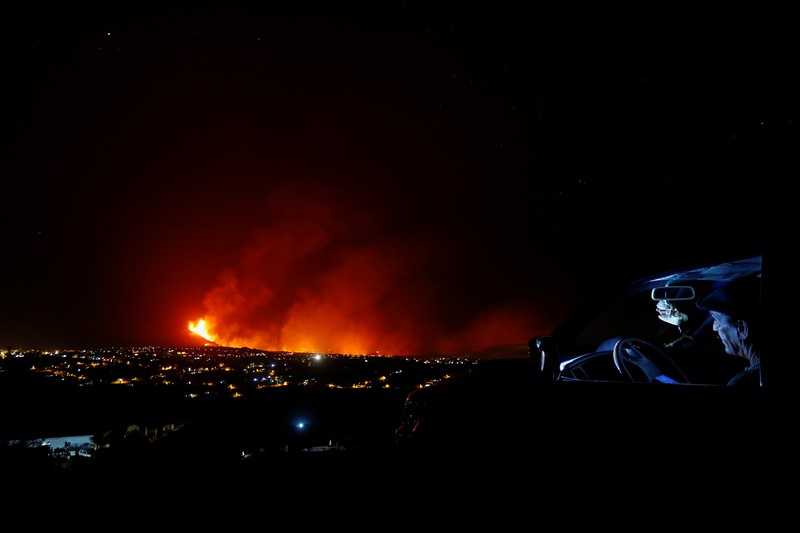 SPAIN-VOLCANO/ A woman climbs a hill with a child to see the Cumbre Vieja volcano as it continues to erupt in Tacande de Arriba on the Canary Island of La Palma, Spain, October 2, 2021. REUTERS/Juan Medina TPX IMAGES OF THE DAY