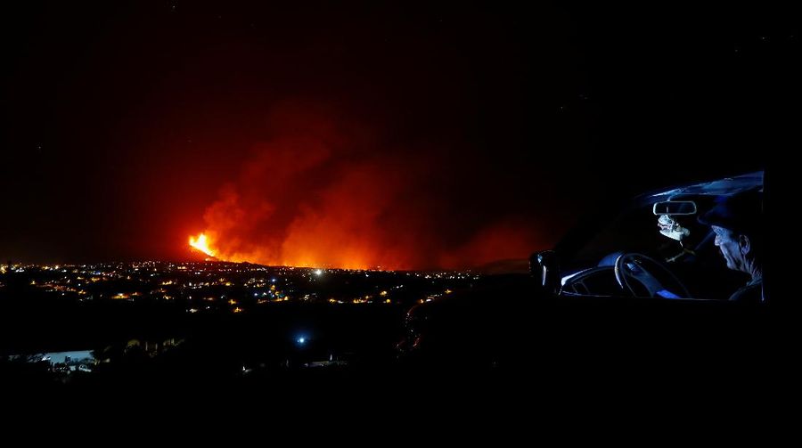 A woman climbs a hill with a child to see the Cumbre Vieja volcano as it continues to erupt in Tacande de Arriba on the Canary Island of La Palma, Spain, October 2, 2021. REUTERS/Juan Medina     TPX IMAGES OF THE DAY
