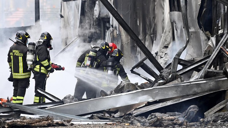 Fire fighters work at the scene where a small plane crashed into a building in San Donato Milanese, Italy, October 3, 2021. REUTERS/Flavio Lo Scalzo