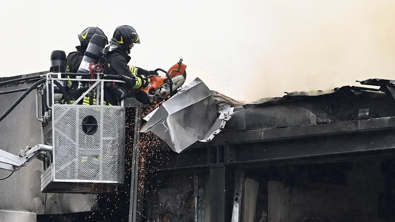 Fire fighters work at the scene where a small plane crashed into a building in San Donato Milanese, Italy, October 3, 2021. REUTERS/Flavio Lo Scalzo