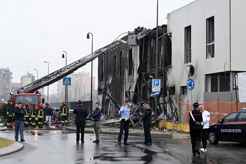 ITALY-CRASH/PLANE Fire fighters work at the scene where a small plane crashed into a building in San Donato Milanese, Italy, October 3, 2021. REUTERS/Flavio Lo Scalzo
