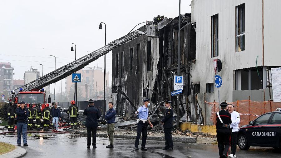 Fire fighters work at the scene where a small plane crashed into a building in San Donato Milanese, Italy, October 3, 2021. REUTERS/Flavio Lo Scalzo