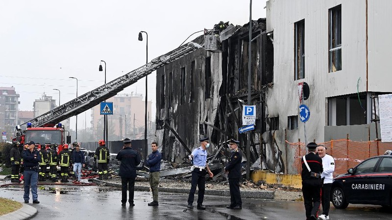 Fire fighters work at the scene where a small plane crashed into a building in San Donato Milanese, Italy, October 3, 2021. REUTERS/Flavio Lo Scalzo