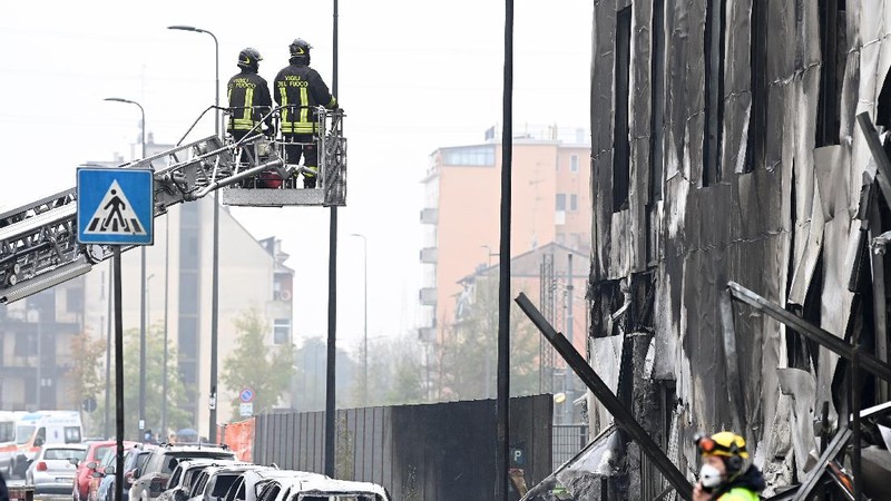 Fire fighters work at the scene where a small plane crashed into a building in San Donato Milanese, Italy, October 3, 2021. REUTERS/Flavio Lo Scalzo