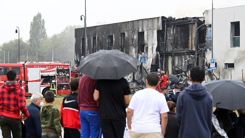 Fire fighters work at the scene where a small plane crashed into a building in San Donato Milanese, Italy, October 3, 2021. REUTERS/Flavio Lo Scalzo