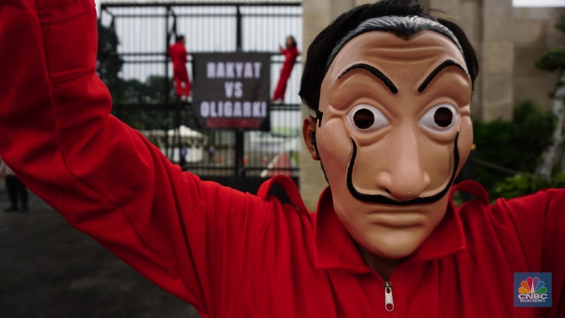 Sejumlah massa yang berkostum topeng ala money heist melakukan aksi di depan gedung DPR RI, Jakarta, Senin (4/10/2021). (CNBC Indonesia/Tri Susilo)