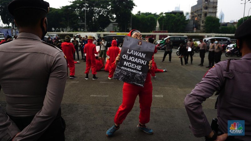 Sejumlah massa yang berkostum topeng ala money heist melakukan aksi di depan gedung DPR RI, Jakarta, Senin (4/10/2021). (CNBC Indonesia/Tri Susilo)