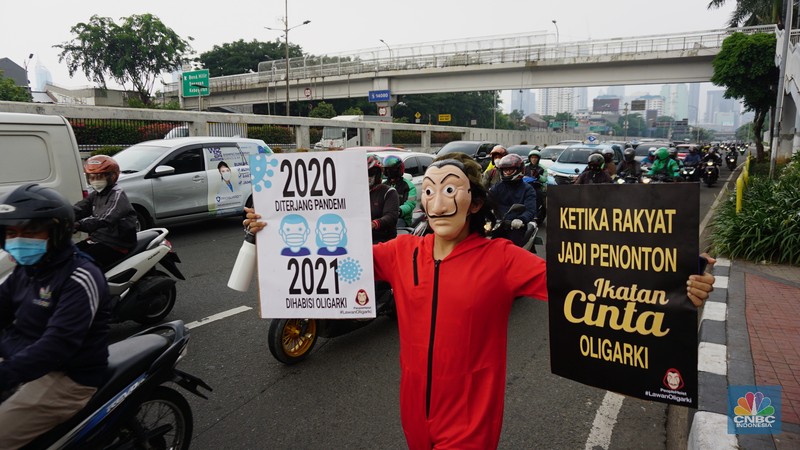 Sejumlah massa yang berkostum topeng ala money heist melakukan aksi di depan gedung DPR RI, Jakarta, Senin (4/10/2021). (CNBC Indonesia/Tri Susilo)