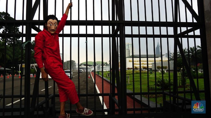 Sejumlah massa yang berkostum topeng ala money heist melakukan aksi di depan gedung DPR RI, Jakarta, Senin (4/10/2021). (CNBC Indonesia/Tri Susilo)