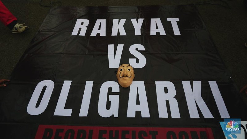 Sejumlah massa yang berkostum topeng ala money heist melakukan aksi di depan gedung DPR RI, Jakarta, Senin (4/10/2021). (CNBC Indonesia/Tri Susilo)