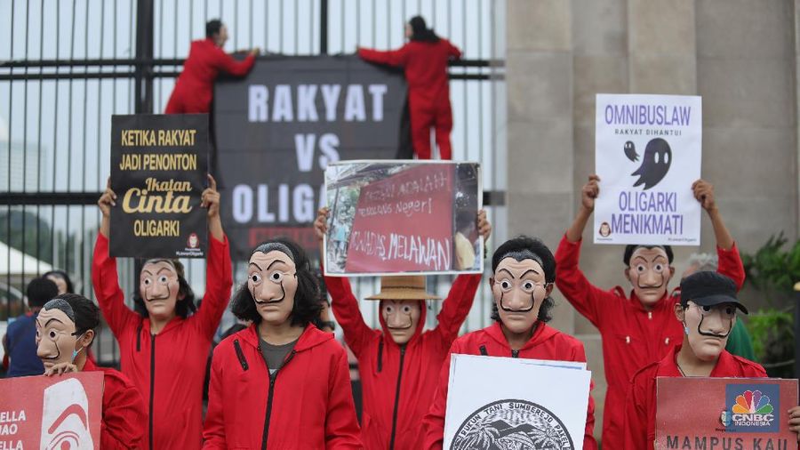Sejumlah massa yang berkostum topeng ala money heist melakukan aksi di depan gedung DPR RI, Jakarta, Senin (4/10/2021). (CNBC Indonesia/Tri Susilo)
