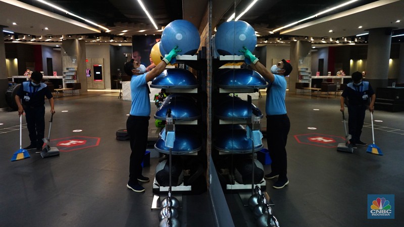 Petugas fasilitas kebugaran Fitness First melakukan pembersihan alat kebugaran di salah satu mal di Jakarta, Selasa (5/10/2021).  (CNBC Indonesia/Tri Susilo)