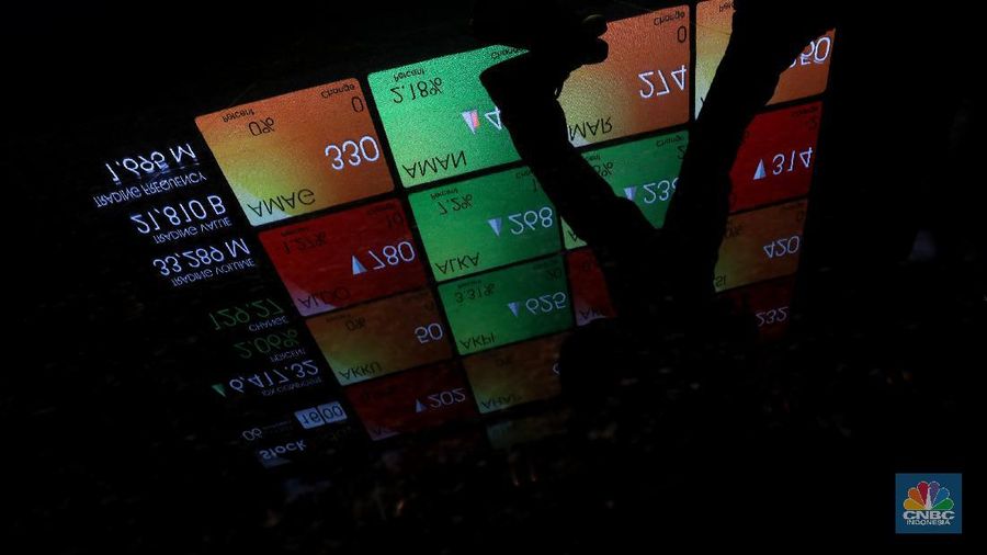 Karyawan melintas di dekat layar pergerakan Indeks Harga Saham Gabungan (IHSG) di gedung Bursa Efek Indonesia, Jakarta, Rabu (6/10/2021).  Indeks Harga Saham Gabungan berhasil mempertahankan reli dan ditutup terapresiasi 2,06% di level 6.417 pada perdagangan Rabu (06/10/2021). (վ/Andrean Kristianto)
