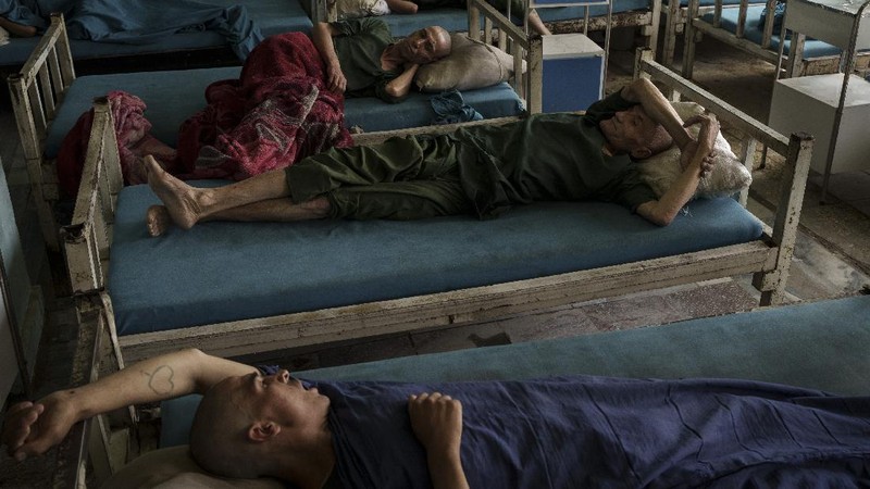 Drug users detained during a Taliban raid wait to be checked at a police station before being transferred to the Avicenna Medical Hospital for Drug Treatment in Kabul, Afghanistan, Friday, Oct. 1, 2021. At least 150 men were taken to the district police station, where all their belongings -- drugs, wallets, knifes, rings, lighters, a juice box -- were burned in a pile since they are forbidden to take them to the treatment center. (AP Photo/Felipe Dana)