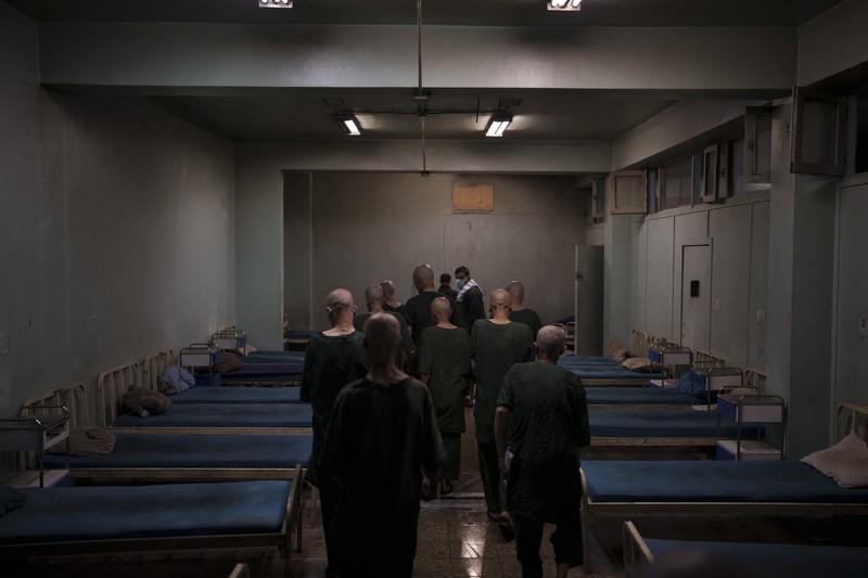Drug users detained during a Taliban raid wait to be checked at a police station before being transferred to the Avicenna Medical Hospital for Drug Treatment in Kabul, Afghanistan, Friday, Oct. 1, 2021. At least 150 men were taken to the district police station, where all their belongings -- drugs, wallets, knifes, rings, lighters, a juice box -- were burned in a pile since they are forbidden to take them to the treatment center. (AP Photo/Felipe Dana)