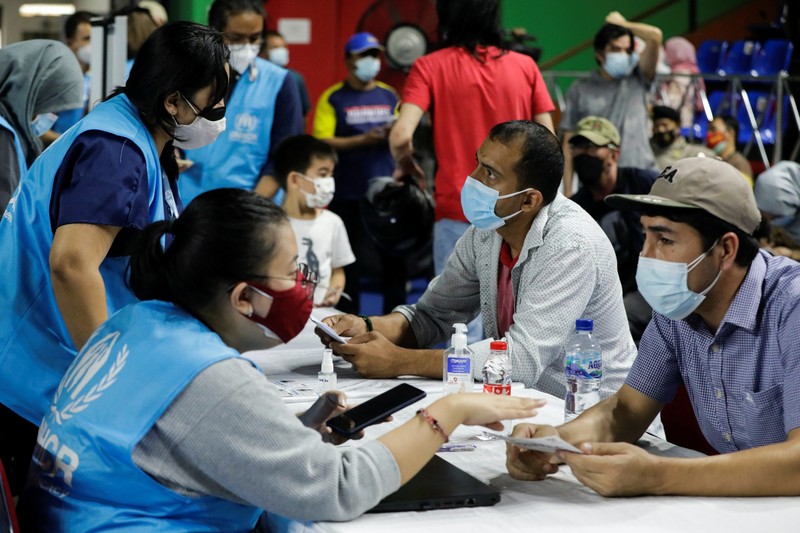 A woman undergoes a health screening before receiving a dose of a vaccine against the coronavirus disease (COVID-19) during a mass vaccination program for asylum seekers and refugees at a sports hall in Jakarta, Indonesia, October 7, 2021. REUTERS/Ajeng Dinar Ulfiana
