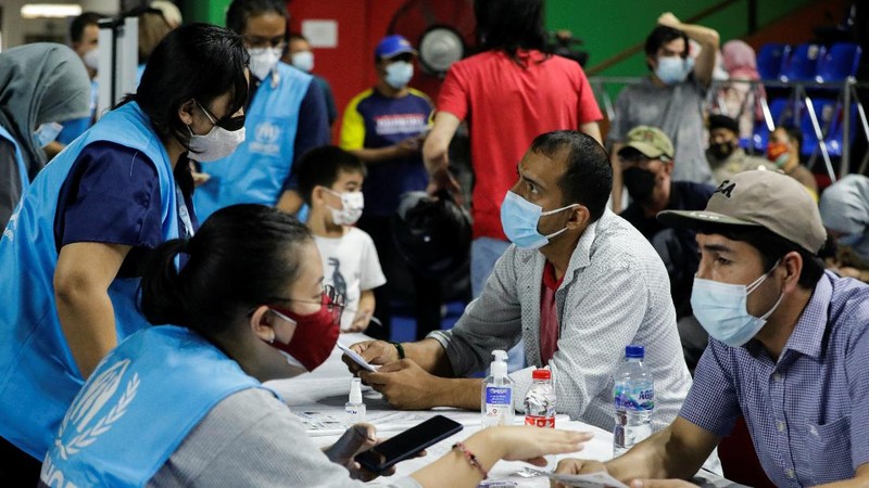 A woman undergoes a health screening before receiving a dose of a vaccine against the coronavirus disease (COVID-19) during a mass vaccination program for asylum seekers and refugees at a sports hall in Jakarta, Indonesia, October 7, 2021. REUTERS/Ajeng Dinar Ulfiana