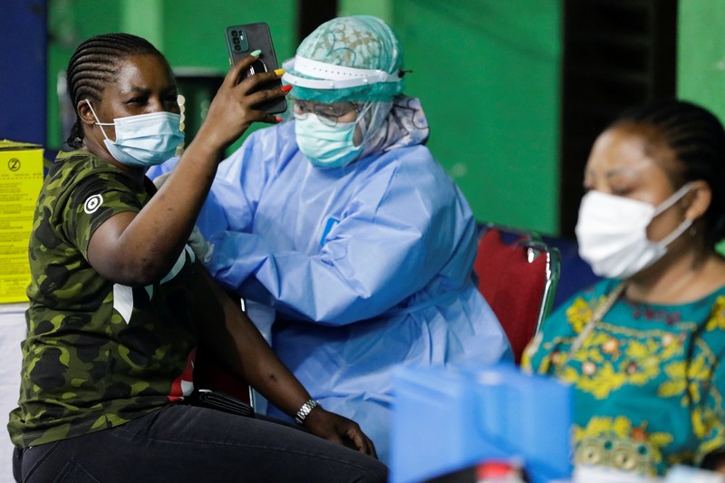 HEALTH-CORONAVIRUS/INDONESIA-REFUGEES-VACCINATION A woman undergoes a health screening before receiving a dose of a vaccine against the coronavirus disease (COVID-19) during a mass vaccination program for asylum seekers and refugees at a sports hall in Jakarta, Indonesia, October 7, 2021. REUTERS/Ajeng Dinar Ulfiana